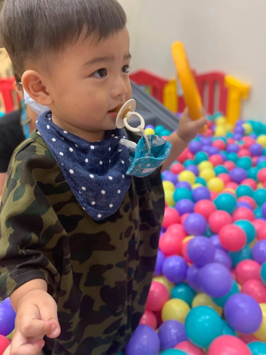 小男生在球池玩夾著蘋安袋