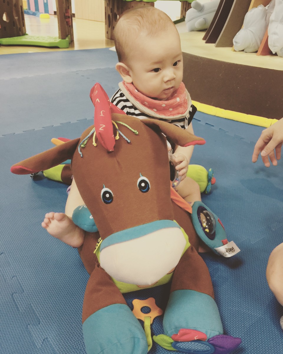 孩子在室內遊玩空間拿著布偶。