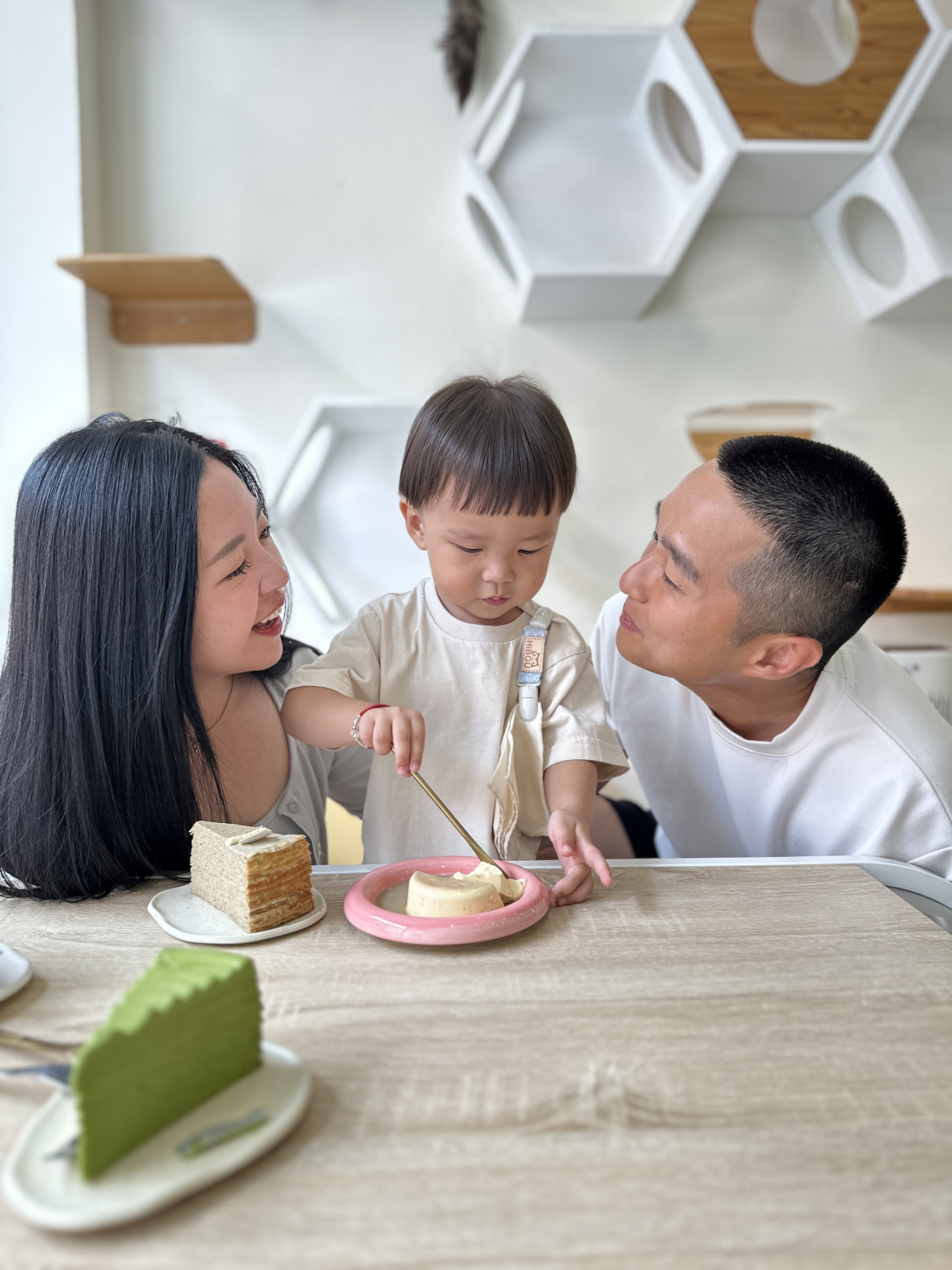 一家人吃點心,孩子上衣旁的短夾掛著布巾