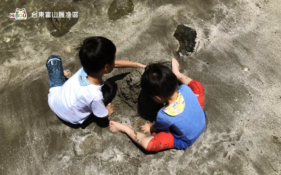 孩子在富山海邊沙地上玩沙的舊旅行照片