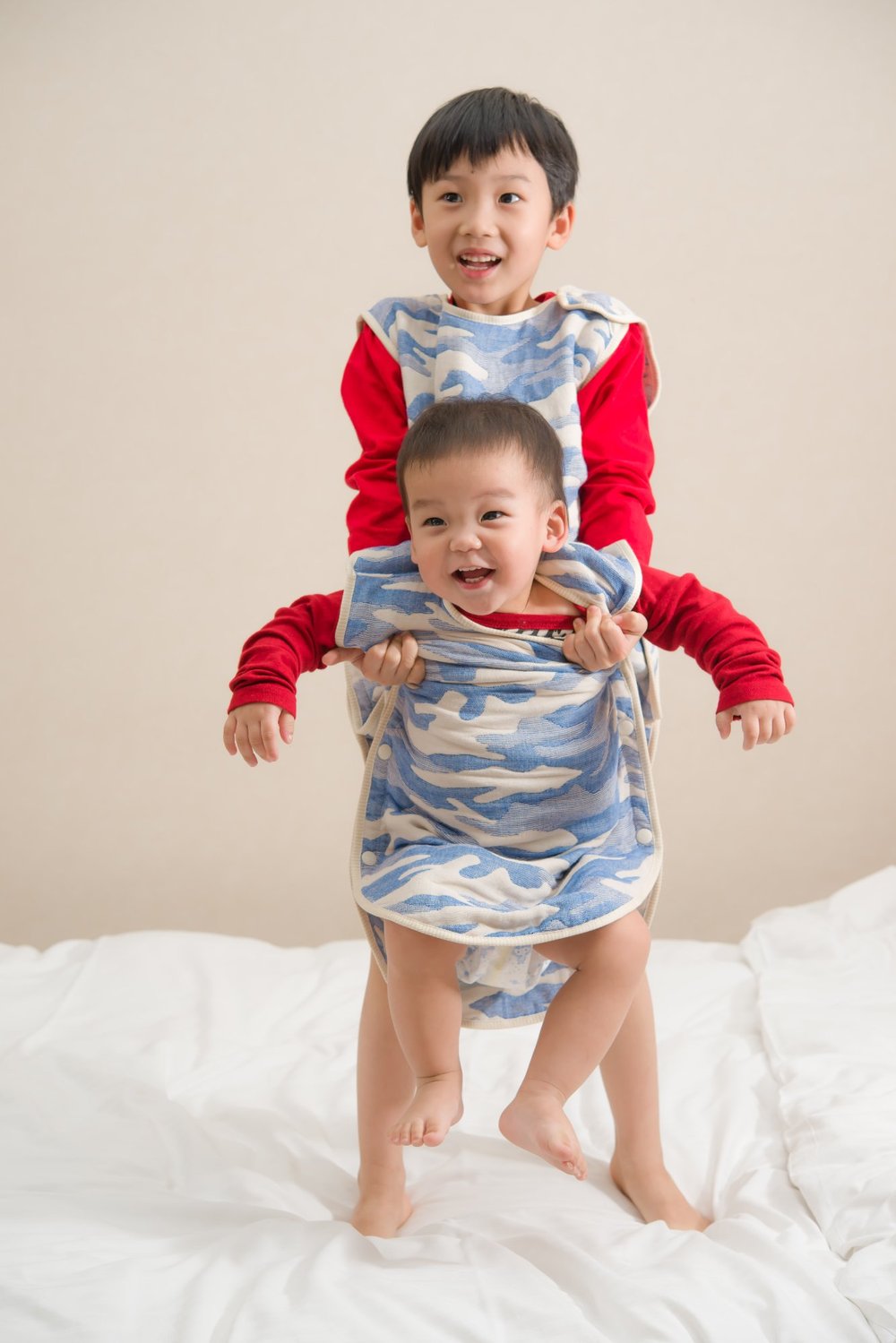 兩位孩子穿著藍色迷彩六重紗防踢被，呈現肩部與衣身穿著外觀