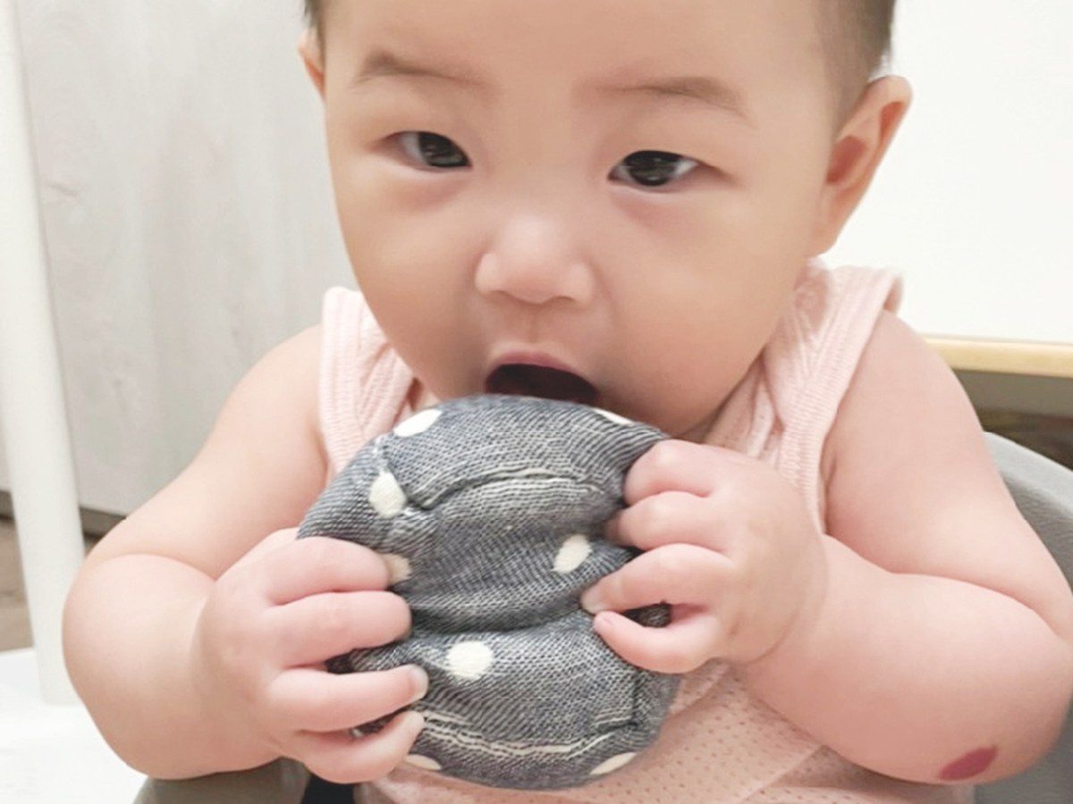 寶寶雙手抱著純棉紗布骰子球探索口腔期玩具