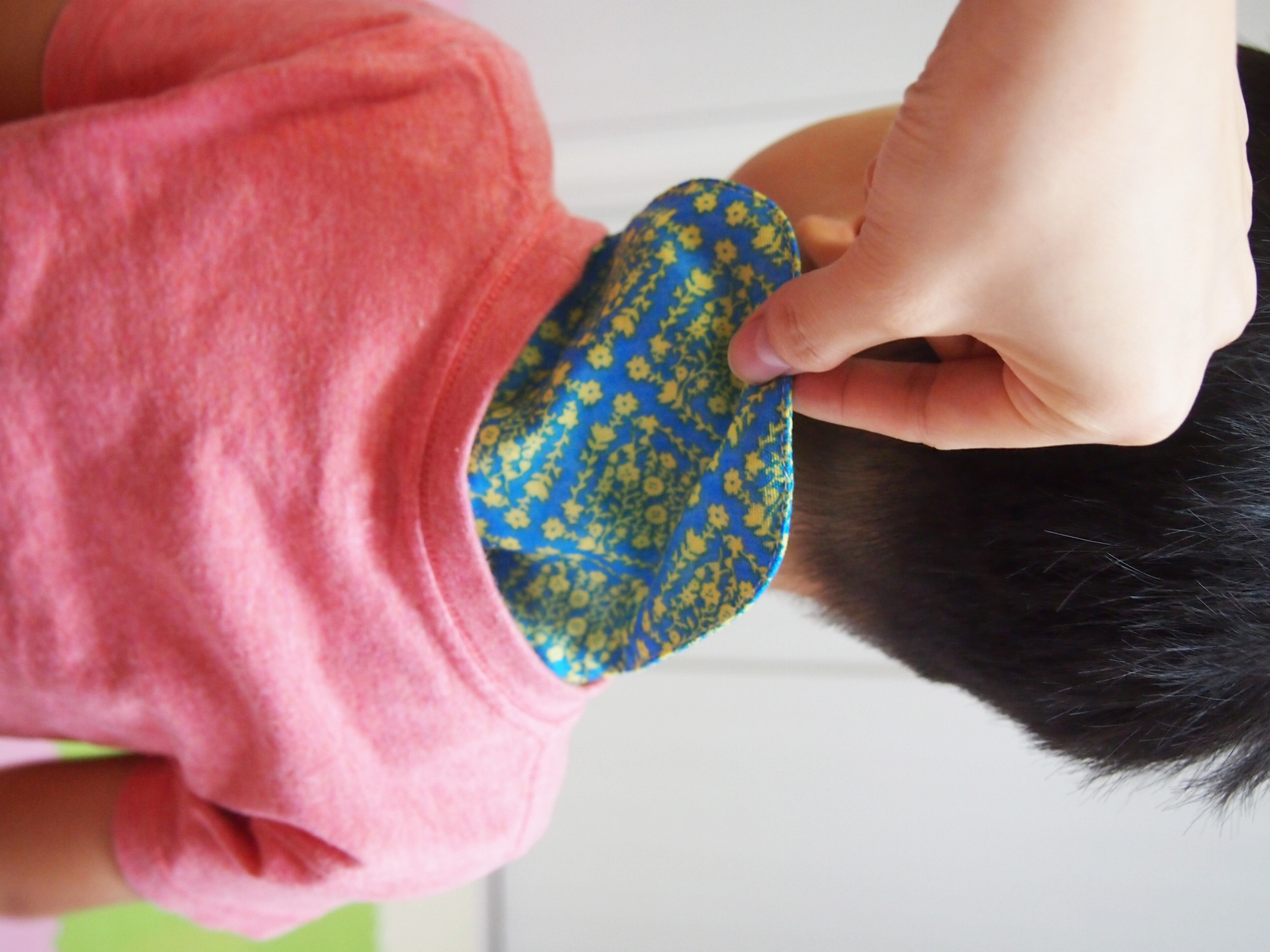 照顧者從孩子衣領取出印花吸汗巾